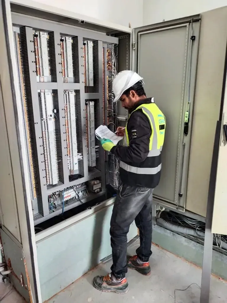 Engineer checking terminations inside an open communications cabinet